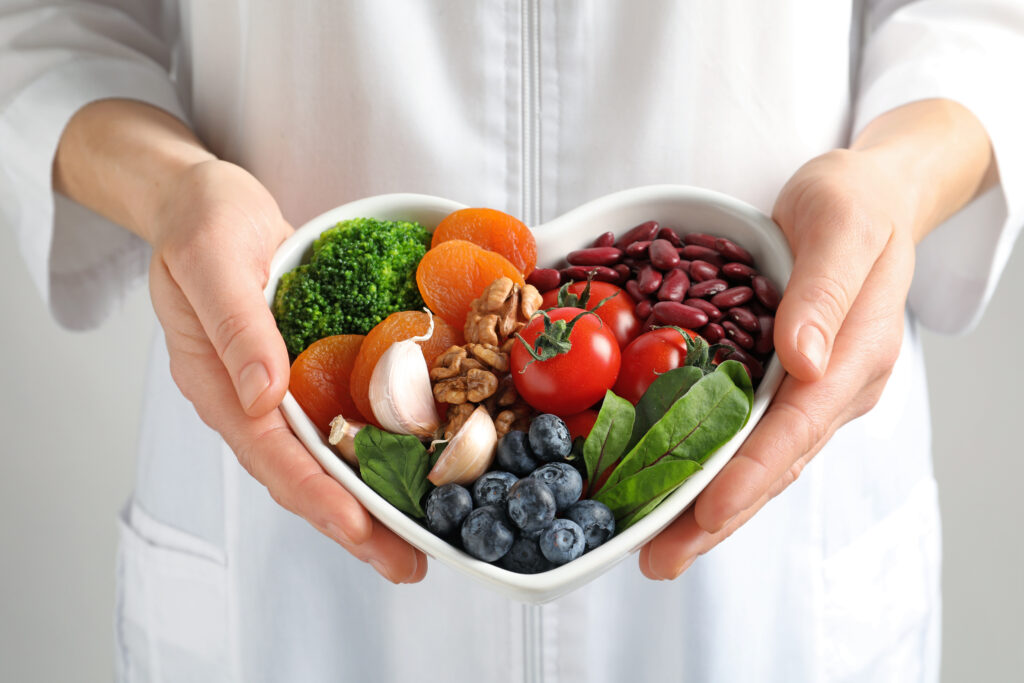 Holding gastritis-friendly food in a bowl in a shape of a heart.