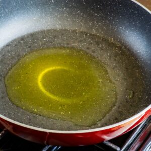 Glistening olive oil heated in a nonstick skillet, ready for the tofu to be added for a golden sear, signaling the start of a flavorful stir-fry adventure.